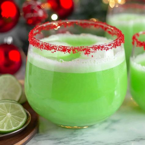 A fun green Christmas punch combining lime sherbet, sprite and Hawaiian punch. Optional red sugar rim for extra festive touch. Holiday Punch With Sherbet, Grinch Sangria Recipe, Sherbet Christmas Punch, Green Christmas Punch, Grinch Punch Recipe For Kids, Punch With Sherbet, Lime Sherbert Punch, Grinch Punch Recipe, Punch Recipes For Kids