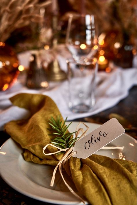 Napkin details: Mustard linen napkins tied with raffia, a sprig of rosemary and a hand written name tag for a personalised touch. Shown here at Gold Notting Hill Christmas Dinner Table Settings, Yellow Napkins, Wedding Runner, Festive Tablescape, Private Dinner, Dinner Party Table, Christmas Dinner Table, Autumn Table, Beautiful Table Settings