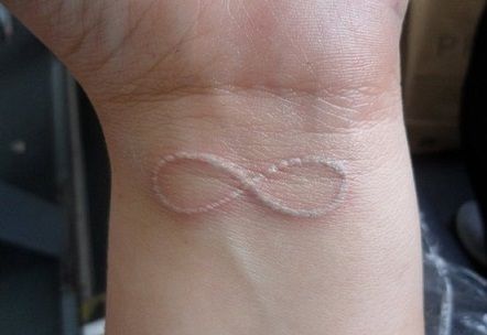 White Infinity Tattoo, White Heart Tattoo, We Are Infinite Tattoo, Infinity With Letters Tattoo, White Wrist Tattoos, Infinity Tattoo With Heart On Wrist, Angel Wings With Infinity Symbol Tattoo, Infinity Butterfly Tattoo, White Heart Tattoos