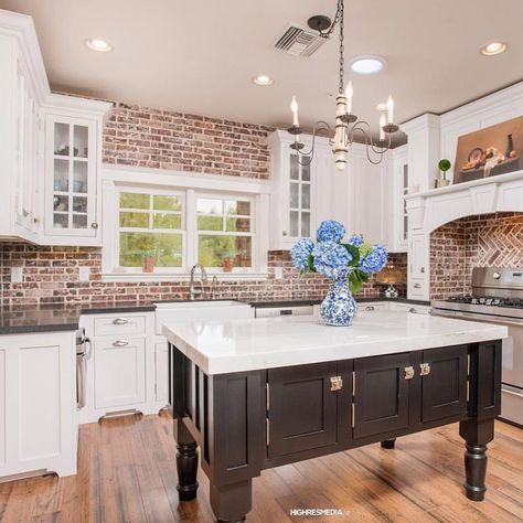 There’s nothing like a kitchen with exposed brick. In this farmhouse kitchen by @highresmedia the white trim and cabinets offset the… White Marble Island, Kitchen With Exposed Brick, Exposed Brick Kitchen, Brick Wall Kitchen, Wood Shelves Kitchen, Brick Backsplash Kitchen, American Farmhouse Style, Farmhouse Industrial, Brick Kitchen