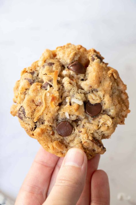 Hand holding a chunky chocolate chip cookie with coconut and pecans. Hotel Cookies, Hotel Chocolate Chip Cookies, Trash Cookies, Doubletree Cookies, Chunky Chocolate Chip Cookies, Cowboy Cookie Recipe, Hotel Chocolate, Nutella Biscuits, Coconut Chocolate Chip Cookies