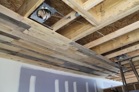 As you know, we’ve been working on disassembling pallets off and on for quite some time now.  We’ve finally started installing some of the pallet ceiling.  We haven’t done too muc… Pallet Roof, Basement Ceiling Ideas Cheap, Wooden Pallet Crafts, Pallet Ceiling, Roof Ideas, Ceiling Insulation, Diy Basement, Basement Makeover, Basement Ceiling