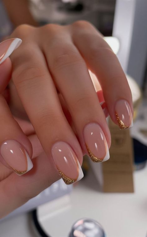 This design elevates the traditional French tip with a twist of glittering gold. Featuring a glossy nude base and clean white tips, the subtle gold details add sophistication, making it a timeless choice for elegant occasions or professional settings. Gold Glitter French Tip Nails, Gold Glitter French Tip, French Tip With A Twist, Glitter French Tip Nails, Glitter French Tip, Glitter French Tips, White Tips, White Tip, French Tips