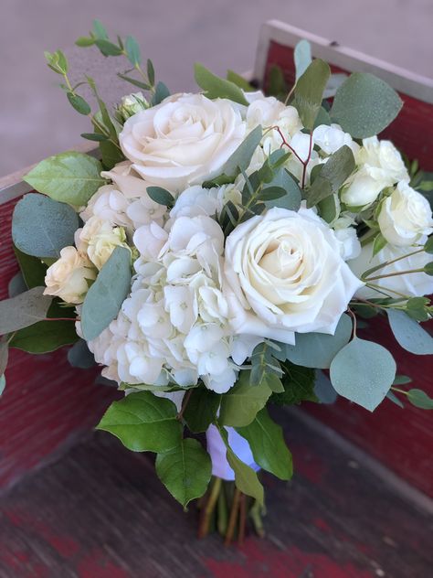 Playa Blanca rises, white hydrangea, spray roses and silver dollar eucalyptus in a handtied bridal bouquet Hydrangea And Rose Wedding Bouquet, Hydrangea And Rose Bouquet With Greenery, White Rose And White Hydrangea Bouquet, Prom Bouquet Ideas White Roses, White Rose Hydrangea Eucalyptus Bouquet, Bridesmaid Bouquet With Hydrangeas, White Hydrangea Bouquet With Greenery, Cream Hydrangea Bouquet, Eucalyptus Hydrangea Bouquet