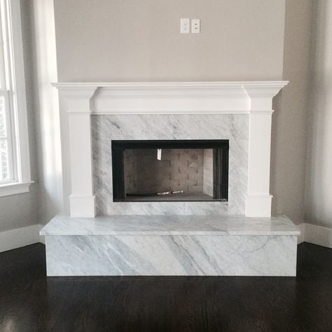 Modern Fireplace Surrounds to Inspire Your Home Classy Fireplace, Marble Fireplace Hearth, Raised Hearth Fireplace, Modern Fireplace Surround, Fireplace Surround Ideas, Carrara Marble Fireplace, Raised Hearth, Rustic Hardwood Floors, Hearth Fireplace