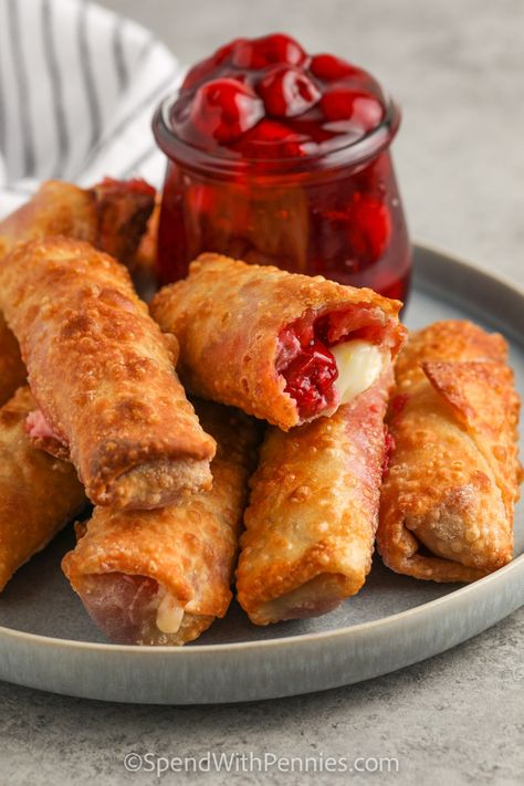 For a super special dessert treat, try making cherry cheesecake egg rolls in the deep fryer or the air fryer. This recipe is easy to make and everyone loves it. Try serving it with blueberry or raspberry pie filling instead of cherry, it's always delish. Whip up a batch of whipped cream for topping, or drizzle these mini cheesecakes with chocolate dip! #cherrycheesecake #spendwithpennies #cherrycheesecakeeggrolls #airfryereggrolls Dessert Egg Roll Recipes, Cheesecake Egg Rolls, Raspberry Pie Filling, Savory Cheesecake, No Egg Desserts, Raspberry Pie, Egg Roll Recipes, Cream Cheese Eggs, Cherry Cheesecake