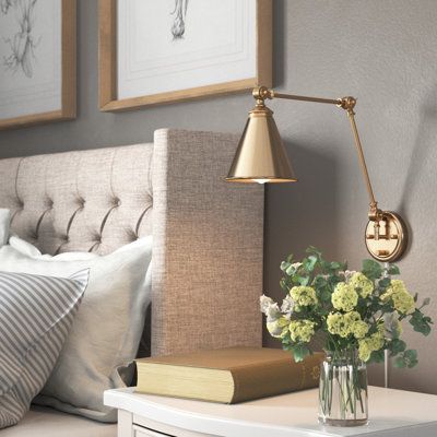 This 1-light wall sconce brings convenient light and classic style to any corner. It's made from metal with a neutral finish, and it has a cone-shaped steel shade for a vintage-inspired look. This sconce features a circular backplate with a slim linear arm that bends and turns to direct light exactly where you want it. The shade holds one standard bulb (sold separately). Whether you place this fixture in your entryway, hallway, or bedroom, it's sure to brighten your space. Finish: Gold | Three P Lights Over Headboard Above Bed, Wall Reading Lights Bedroom, Wall Mount Bedside Lamp, Sconces Bedroom Master Suite, Headboard With Sconces, Bedside Sconces Wall Mount, Bedroom Wall Sconces Bedside Lighting, Bedside Lighting Ideas, Bedroom Sconces Bedside