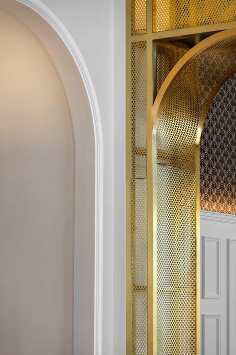 The shelves are made of brushed brass metal mesh with integrated LED lighting and with wooden shelves produced from dark timber. The design was inspired by the hotel building lines and original archways. Mesh Lighting, Wooden Arch, Arch Interior, Hotel Building, Metal Arch, Arched Doors, College Design, Hotel Interiors, Cafe Interior Design