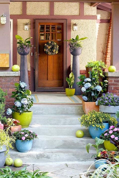 Brightly colored containers can enhance the plants in them and add an element of fun to your front porch display. To avoid a busy look, add only one type of plant per pot, and restrict your overall color palette to no more than three main colors. #gardenideas #gardening #outdoordecor #porch #containergarden #landscaping #bhg Front Porch Planter Ideas, Front Porch Planter, Porch Planter Ideas, Front Porch Flower Pots, Porch Planter, Front Porch Flowers, Front Porch Steps, Front Porch Planters, Beautiful Front Doors