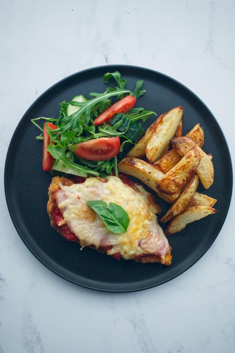 Chicken Parmigiana, or Chicken Parma as it’s best known in Australia, is a delicious chicken schnitzel dish topped with ham, cheese and tomato sauce. Baked Chips Recipe, Chicken Parma, Oven Baked Chips, Cheese And Tomato, Chicken Ham, Chicken Schnitzel, Chicken Parmigiana, Australia Food, Ham Cheese