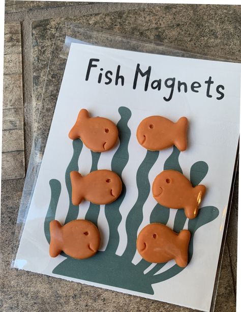 This Goldfish Cracker Magnet Set is a perfect addition to any workspace, perfect for teachers looking to add novelty magnets to their collection of fun teaching accessories.  𝐏𝐑𝐎𝐃𝐔𝐂𝐓 𝐈𝐍𝐅𝐎𝐑𝐌𝐀𝐓𝐈𝐎𝐍:  * Each fish magnet is 1 inch long and  1/2 inch wide.  * 6 fish magnets in a pack  * Each magnet will hold 3 pieces of paper  * Each magnet is hand made with Polymer clay and may differ slightly from     the picture.  𝐇𝐎𝐖 𝐓𝐎 𝐎𝐑𝐃𝐄𝐑: * Choose quantity * Add to cart 𝐒𝐇𝐈𝐏𝐏? Teacher Magnets, Laneway House, Polymer Clay Magnet, Pottery Cafe, Clay Animation, Clay Pins, Diy Magnets, Clay Magnets, Clay Things