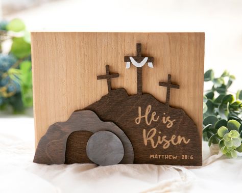 Celebrate the Easter season with this beautifully crafted, "He is Risen" wooden sign. Hand-made from cedar wood/high quality birch plywood and featuring a stunning combination of paint, stain, and engraving, this Christian religious decor will make a meaningful addition in your home this Lenten season.  Note: this piece will "stand" on its own. Size: 7" x 5.5" x ~7/8" Christian Decorations Home, Christian Wood Burning, Cross Wood Projects, Christian Wood Signs, He Is Risen Art, He Is Risen Craft, Easter Paintings, Cross Decor, Empty Tomb