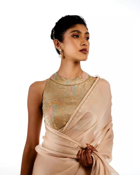 Old-world grandeur, combined with modern-day effortlessness. The rose gold Triveni saree wraps around our lush satin silk tissue blouse, intricately handwoven with multicolored tanchoi meenakari and adorned with majestic peacocks. Jewelry courtesy: @thehouseofrose #Tilfi #TilfiSarees #TilfiIcons Unstitched Elegant Tissue Silk Blouse Piece, Luxury Pre-draped Tissue Silk Saree, Tissue Silk Saree Blouse Fitted, Luxury Tissue Silk Pre-draped Saree, Gold Embroidered Pre-draped Tissue Silk Saree, Bridesmaid Saree, Unique Blouse Designs, Blouse Models, Unique Blouse