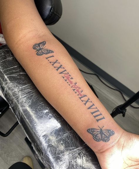 Forearm Tattoos For Women Meaningful, Rip Tattoos Black Women, Forearm Tattoos Names, Butterfly Tattoo With Roman Numerals, Butterfly Tat With Name, Small Tattoo Black Women, Name Tattoos For Women Forearm, Side Of Forearm Tattoo Women, Inner Upper Arm Tattoos For Women