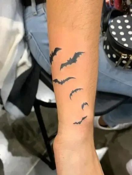 Transform your body into a stunning canvas with these 210+ mesmerizing bat tattoo ideas! From tiny symbols to bold and intricate designs, find inspiration for your next tattoo masterpiece. #battattoo #inked #bodyart Bats On Arm Tattoo, Bats Forearm Tattoo, Bat Tattoo On Wrist, Bats Tattoo Arm, Bat Tattoo Forearm, Bat Forearm Tattoo, Tattoos For Women Small Wrist, Bat Tattoo Arm, Bat Hand Tattoo