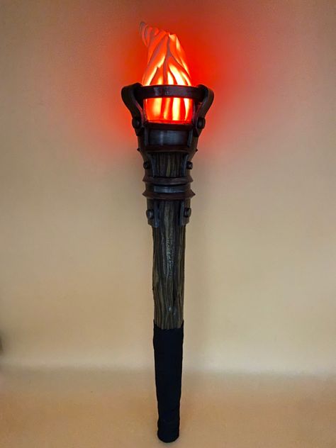 Made of plastazote foam, textured wood effect, with veins and handle in cotton webbing. The flame is set in a double round of foam rings painted in iron color. Midevil Torches, Fantasy Props Diy, Medieval Fantasy Decor, Medieval Party Decorations, Medieval Torch, Character Needs, Torches Diy, Medieval Props, Trojan Women