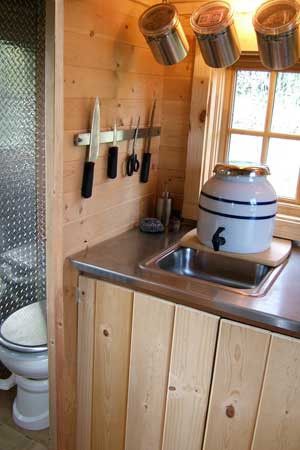 A few good space saving kitchen ideas: Magnetic knife holders and hanging lidded containers. Dry Cabin, Tumbleweed Tiny Homes, Off Grid Tiny House, Tiny House Company, Off Grid Cabin, Building A Tiny House, House Names, Tiny Cabins, Tiny House Bathroom