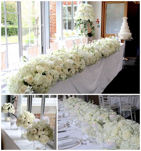 A breathtaking top table long runner display, full of  white bloomy flowers of hydrangeas, roses, peonies and scented stocks studded with tall stemmed votives and floating candles, to create this dreamy look, Botleys mansion, Surrey Botleys Mansion, Wedding Bridal Table, Candlelit Ceremony, Flower Runner, Ceremony Aisle, White Roses Wedding, Roses Peonies, All White Wedding, Bridal Table