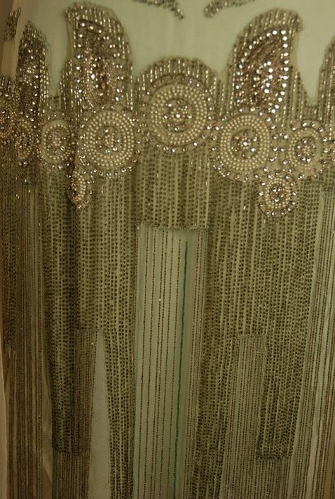 JEWELED DRESS with BEADED FRINGE, 1920's. White chiffon with deep "U" neckline front and back trimmed with a wide band of pearl, rhinestone and crystal bead medallions, wide jeweled hip band with graduated long beaded fringe, chiffon flower and drape at left shoulder, attached aqua underdress possibly not original. -Detail Front 3 1920s Textiles, 1920s Beading, 20s Fashion Gatsby, Lucile Dress, 1920 Dresses, Vinatge Dress, Art Deco Embroidery, Mom Prom, Couture Beading