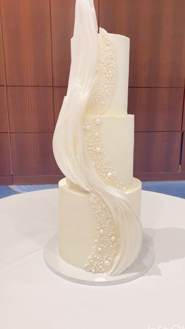 Dinika S Johnson• Wedding & Custom Cake Designer on Instagram: "• P E A R L + W A F E R P A P E R • 
.
.
.
.
.
.
.
.
This was the first time I’ve done structured pearls on a cake. The end result was a textured beauty with waves of wafer paper. 🤍
 
.
.
.
.
.
.
.
.#weddingcakes #atlantaweddings #atlantawedding #atlantaweddingcakes #atlantacake #atlantacakes  #atlantacakeartist #atlantaweddingcakebaker #atlantaevents #atlantaevent #whiteweddingcake #pearlcake #atlantabridal #waferpapercake #Weddingcake #weddingcakes #atlantaweddings #atlantawedding #atlantaweddingcakes #atlantacake #atlantacakes  #atlantacakeartist #atlantaweddingcakebaker #atlantaevents #atlantaevent #whiteweddingcake #atlantaweddingplanner #contemporarycakes #atlantabridal #cakedesign #atlantabrides #atlantaweddingvendors Pearls Wedding Cake, Pearl Cake Wedding, Modern Wedding Cake Designs, Pearl Wedding Cake, Wedding Cake Pearls, Pearl Cake, Wafer Paper Cake, Modern Wedding Cake, White Wedding Cake