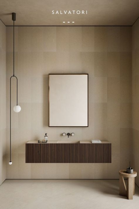 Beautiful bathroom in shades of beige and brown. Natural beije stone is used for the walls and floors. A pleasing play of lighting is produced by the contrast between the smooth texture of the floor and the wrought texture of the wall. The natural stone sink, which echoes the hues of the floor and wall coverings, is set within the huge hanging storage unit, made of dark brown wood. The outcome is one of a warm and inviting restroom. Brown And Beige Bathroom, Beige And Brown Bathroom, Warm Bathroom, Exterior Furniture, Beige Bathroom, Brown Bathroom, Bespoke Interiors, Glass Cabinet Doors, Small Bathroom Design