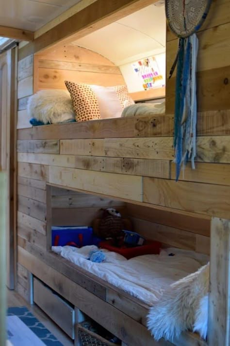 The parents' bed converts into a play area during the day. There are bunk beds along the wall for the kids, and a crib for the baby. Bus Remodel, School Bus Tiny House, School Bus Camper, School Bus House, Converted School Bus, Old School Bus, Diy Bunk Bed, Bus Living, Short Bus