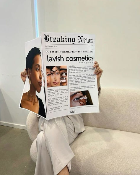 A person sitting on a modern couch holding a newspaper featuring bold headlines about 'lavish cosmetics' with images of diverse beauty models. This cosmetics branding mockup provides inspiration for innovative, editorial-style photoshoots, perfect for graphic designers and businesses looking to create fresh, impactful visuals for brand promotions. Business Owner Photoshoot, Newspaper Mockup, Cosmetics Branding, Cosmetics Company, Salon Suites, Business Photoshoot, Branding Photoshoot Inspiration, Aesthetic Content, Personal Branding Photoshoot