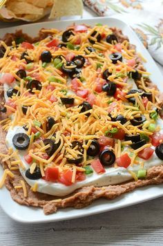 Layered Ranch Taco Dip - layers of refried beans, sour cream with ranch, tomato, olives, cheese, and more! No cooking involved! Ranch Taco Dip, Ranch Bean Dip, Layered Taco, Fake Ginger, Taco Dip Recipe, Layered Taco Dip, Spreads Recipes, Delicious Dips Recipes, Creamy Ranch