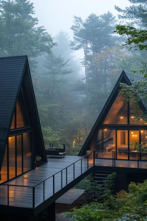 Two connected modern a frame houses full glass walls with black roofs wheathered grey wood shared deck with steps and with black metal railings. Check out all of these stunning and chic dark A-frame houses that pack a ton of charm into a small forest retreat. Two Cabins Connected, Custom A Frame Homes, A Frame Barndominium, A Frame Cabin Interior Ideas, Black Tiny Home, Black And Wood House, A Frame Windows, Black A Frame House, Dark Forest House