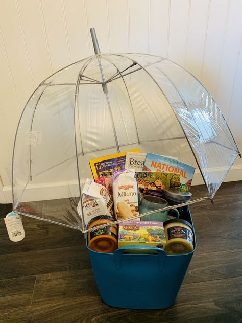 Volunteered to make a “basket” for a silent auction fundraiser. I decided on a “Peaceful Rainy Day” theme. Ended up getting a cool clear bubble umbrella, three different magazines on different subjects (meditation and mindfulness, science and stargazing, and the US National Parks), a Calvin and Hobbes comic anthology, Cadbury hot coco mix, a mug, Pepperidge farms cookies, a snoopy 100 piece puzzle, lemon lavender tea, a nice mellow scented candle, and two different Campbell’s slow cooker soups! Rainy Day Gift Basket, Cheap Silent Auction Basket Ideas, Rainy Day Gift Basket Ideas, Umbrella Gift Basket, Fundraiser Baskets Themed, Rainy Day Auction Basket Ideas, Rainy Day Basket, Rainy Day Raffle Basket, Themed Gift Baskets Silent Auction