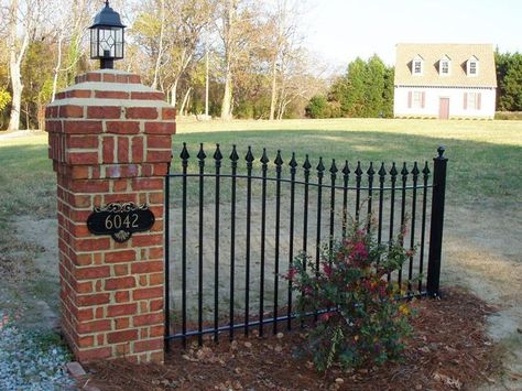 A corner view of our astonishing fence with brick pillars and a ... Brick Pillars Driveway Entrance, Brick Columns Driveway, Iron Fence Panels, Brick Pillars, Driveway Entrance Landscaping, Brick Driveway, Patio Railing, Brick Columns, Driveway Entrance