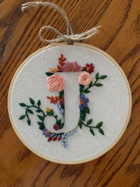 Custom made, hand embroidered floral letter. Made with 100% cotton fabric as well as DMC 100% cotton thread. The hoop used is 5 inches in diameter, natural wood. Completed with paper backing to protect stitching.  Can create any letter. The colour schemes to choose from will represent the majority of the colours used for the flowers with some variation used for smaller flowers, stems and leaves.  This will make a perfect gift for anyone. Lovely for kids rooms and nurseries, birthday and shower g Flower Letters Embroidery, F Embroidery Letter, Hand Embroidered Initials, Embroider Gift Ideas, A Letter Embroidery Design, Embroidered Letters Floral, B Embroidery Letter, K Embroidery Letter, J Embroidery Letter