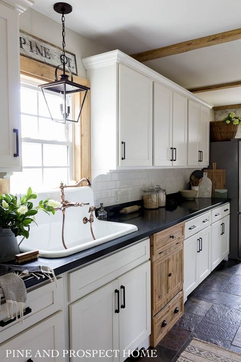 Farmhouse kitchen with a wood dishwasher panel #kitchendecor #farmhousekitchen #farmhousedecor #farmhouse #fixerupper #whitekitchen #kitchen #rusticdecor Hidden Refrigerator, Pine And Prospect Home, Pine And Prospect, Farm Sinks, Lanterns Chinese, One Wall Kitchen, Cottage Style Kitchen, White Subway Tile Backsplash, Black Countertops