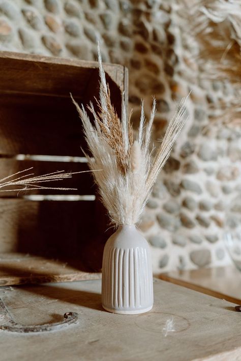 This shows a close up of a off white bud vase, with dried flowers in it. In the background is a wooden crate. Vase With Dried Flowers, Ceramic Bud Vases, Barn Photography, Vase Collection, Modern And Antique, Boho Modern, Rustic Boho, Rustic Barn, Vases And Vessels