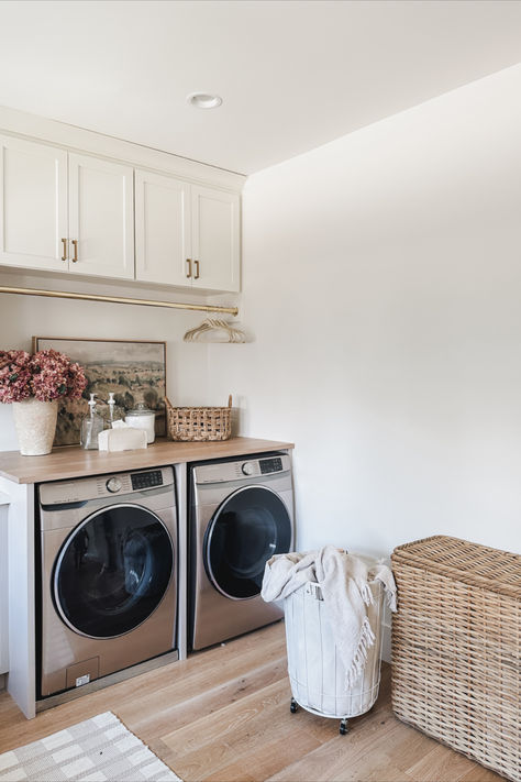 Spring laundry room details! Light and airy space with aesthetic organization and gold details   Home finds, spring refresh, laundry room details, aesthetic home, neutral home, laundry basket, velvet hanger, gold details, glass dispenser, neutral area rug, Pottery Barn style, Target, found it on Amazon, faux florals, tissue box, basket faves, organization details