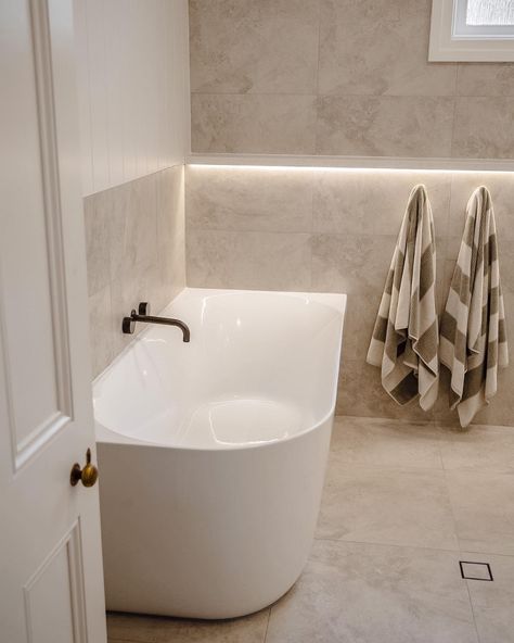 How incredible is this bathroom space by @NavyBoxConstructions?! Achieving the spa like feeling with the Posh Solus back-to-corner bath paired with the timeless white shaker style Kado Lux vanity. Contrasted by the Milli Pure tapware in brushed gunmetal with beige, textured tiles for a bright and inviting bathroom. 

Reece featured products 🛁 :
Milli Pure tapware, Milli Mood shower, Kado Lux vanity, Posh Solus back-to-corner freestanding bath. Brushed Gunmetal Bathroom, Shaker Style Bathroom Ideas, Light Beige Bathroom, White Beige Bathroom, White And Beige Bathroom, Hamptons Bathroom Ideas, Gunmetal Tapware, Beige Bathroom Tile, Beige Tile Bathroom