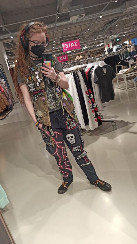 Non-binary person in crust patches pants and battle vest makes a mirror selfie in a store Battle Pants, Punk Vest Outfit, Battle Vest Outfit, Punk Overalls, Patch Pants Ideas, Crust Pants Patch Ideas, Crust Punk Style, Punk Vest, Eco Punk