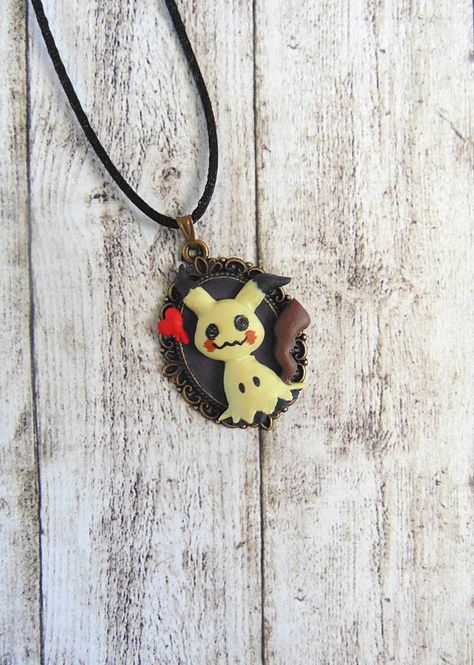 pokemon mimikyu mimigma polymer clay necklace pendant Crochet Mimikyu, Pokemon Earrings Diy, Snorlax Polymer Clay, Mimikyu Polymer Clay, Mimikyu Keychain, Giratina Pokemon, Clay Pokemon, Pokemon Necklace, Pokemon Jewelry