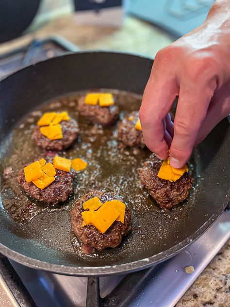 Cooking burger sliders with cheese on the stove Oven Sliders, Cast Iron Skillet Burgers, Sliders Recipes Hamburger, Skillet Burgers, Cast Iron Burgers, Ground Beef Sliders, Oven Burgers, Turkey Burger Sliders, Hamburger Sliders