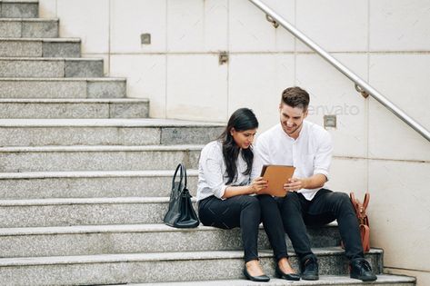 Business people sitting on steps by DragonImages. Young multi-ethnic business people sitting on steps and reading article on tablet computer #Sponsored #steps, #DragonImages, #Young, #Business People Sitting On Stairs, Young Multi, Dragon Images, How To Read People, Tablet Computer, People Sitting, Business People, Naruto Art, Pose Reference