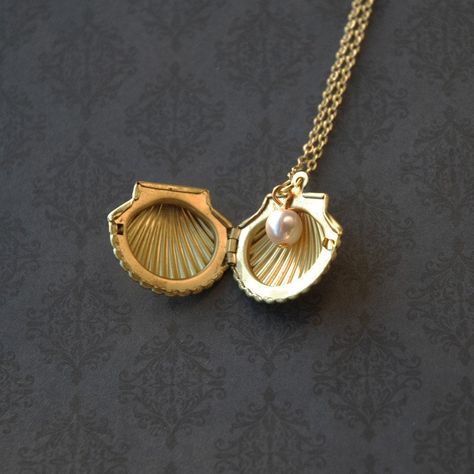 "Beautiful raw brass seashell locket necklace. This clam shaped locket measures around 23mm wide. The stamped raw brass locket is light-weight and detailed. This ocean-themed locket necklace is embellished with a Czech glass pearl on the side. ♥ Raw brass locket measures approx. 23mm wide ♥ Czech Glass Pearl ♥ 18\" Gold-plated necklace ♥ Always gift wrapped ♥ + Please note that this is a stamped raw brass locket! If you are not okay with this item being an original stamped raw brass locket, and Seashell Locket Necklace, Clam Pearl Necklace, Mermaidcore Aesthetic Jewelry, Pearl Locket Necklace, Brass Hair Accessories, Vintage Gold Shell Jewelry, Vintage Shell-shaped Necklaces For Gifts, Ocean Themed Gifts, Ocean Themed Jewelry