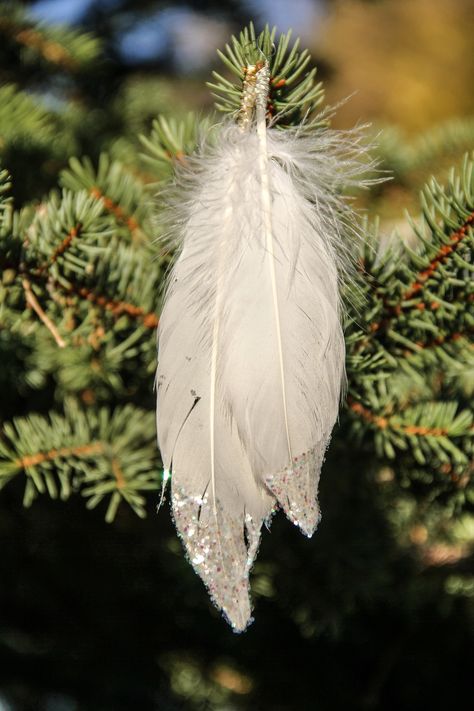 These are beautifully handmade glitter dipped feather ornaments.  Made with (cruelty free) real feathers in white, snow white glitter, and wire wrapped  with a loop at the end for hanging.  These unique, one of a kind ornaments look beautiful on  a Christmas tree or anywhere else in the house where a little extra touch of glitter is needed!    -Sold in packs of 4  -Metal wire color options: Gold or Silver -Feather lengths varies between 7-8 inches  Shipping: Ships in 3-5 business days Please note that these are made with real feathers and due to their individual natural beauty, sizes may vary.  Feathers are also very fragile by nature so please keep out of the reach of children and avoid bending feathers to prevent them from breaking. Feather Ornaments, Dipped Feathers, Holiday Window Display, Christmas Pine Cones, Special Events Decor, Fall Thanksgiving Decor, Feather Crafts, Glitter Dipped, Feather Tree