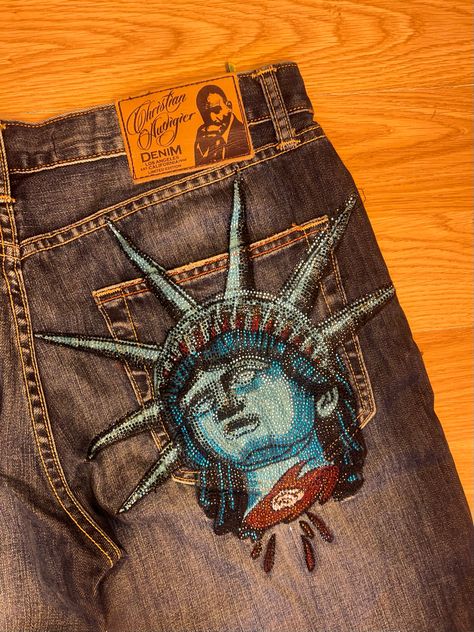 Christian Audigier Jeans, Jean Painting Ideas, Ed Hardy Jeans, Apparel Design Inspiration, Jeans Design, Diy Clothes Design, Custom Denim, Painted Jeans, Christian Audigier