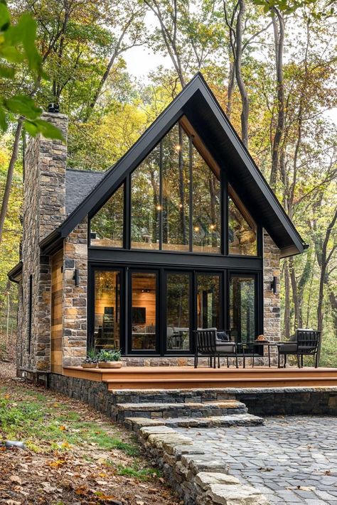 Tiny modern luxury 2 story cottage with sloped roof stone siding large modern windows in black trim small wooden deck with steps cobblestone yard. Find out how a pint-sized palace can offer both opulence and efficiency without cramping your style.