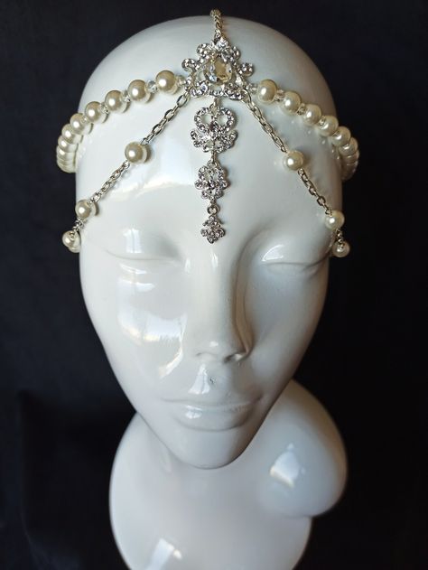 Looking for a stunning headpiece to complete your bridal look?  Check out our Great Gatsby-inspired headpiece, perfect for adding a touch of vintage glam to your hairstyle.  The bridal head chain is adjustable to fit any head size and is lightweight and comfortable to wear.  This headpiece will make you feel like a true goddess on your special day. Order now and add some sparkle to your bridal look! READY to SHIP It is weight about 50g Packaging: It is carefully shipped in a beautiful organza pouch with drawstring, bubble wrapped and well protected. It is also possible to order slave-bracelet in the same design as a set for creating ideal look just contact me.  More tikka here https://www.etsy.com/your/shops/JewelryFashionArt/tools/listings/section:19479022,view:table,stats:true Welcome to 1920s Pearl Headpiece, Chain Hair Piece, Cool Headpieces, Cool Head Pieces, Head Crowns Headpieces, Head Jewelry Headpieces, Burlesque Jewelry, God Accessories, Bridal Head Chain