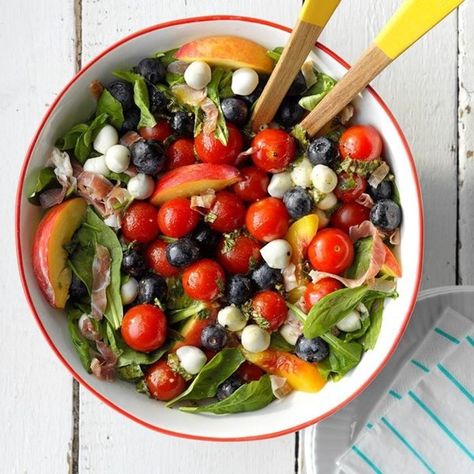 A red-rimmed white bowl hold a colorful salad with mozzarella pearls, blueberries, cherry tomatoes, and other ingredients Fourth Of July Traditional Food, Salad Caprese, Summer Potluck Recipes, Patriotic Recipes, Ensalada Caprese, Blue Salad, Summer Potluck, Popular Side Dishes, Delicious Magazine