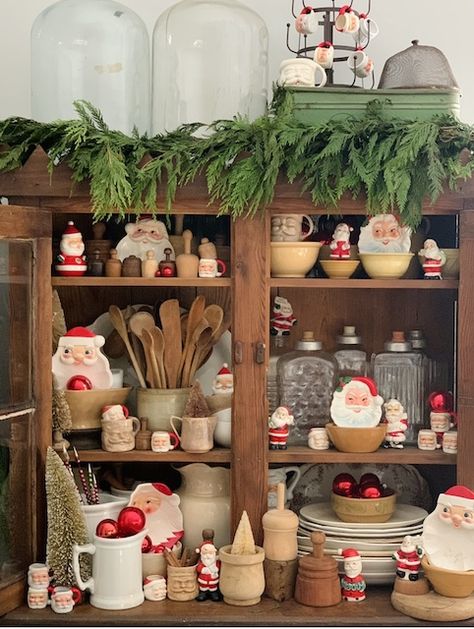 Vintage Santas In The Kitchen Vintage Santa Tablescape, Kitchen Hutch Christmas Decor, Vintage Santa Christmas Decor, Christmas Vintage Decor, Vintage Santa Decor, Vintage Christmas Vignettes, Santa Display Ideas, Santa Kitchen Decor, Christmas Cabinets