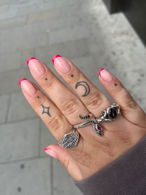 Small finger tattoos, finger tattoo dots, silver rings, pink and red nails Cuticle Dot Tattoo, Finger Tattoos Edgy, Sagittarius Tattoo Finger, Starburst Finger Tattoo, Finger Tattoo Traditional, Tattoo Dots On Fingers, Small Toe Tattoos, Red Tattoo Finger, Finger Dots Tattoo