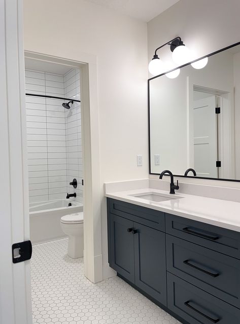 Black Hexagon Tile Bathroom White Vanity, White Bathroom With Dark Cabinets, Black And White Bathroom With Colored Vanity, Black And White Bathroom With Wood Floor, Black Hardware In Bathroom, Charcoal Vanity Bathroom Ideas, Black Appliance Bathroom, Navy Kids Bathroom, Modern Bathroom Hexagon Tile