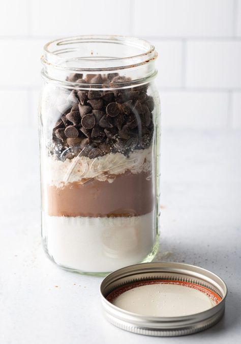 Homemade Ghirardelli brownie mix, dry ingredients layered in a large mason jar with lid off and next to the jar. Brownie Mix Jar, Mason Jar Brownies, Mason Jar Brownie Mix Recipe, Ghirardelli Brownies, Brownie Mix In A Jar, Ghirardelli Brownie Mix, Brownies In A Jar, Homemade Brownie Mix, Brownie Mix Recipes